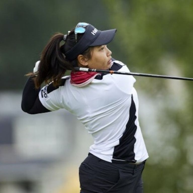 a woman after hitting a golf ball