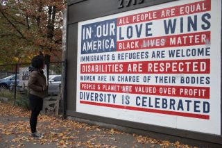 A woman looks at an outdoor mural