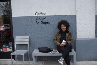 a woman sits and holds a cup of coffee