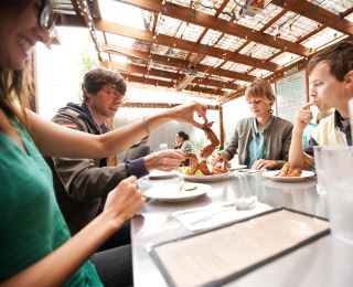 A group of people enjoying fried chicken wings, a favorite at Pok Pok