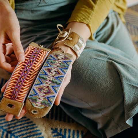 Jewelry designer Caroline Blechert examines two of her finished cuffs.