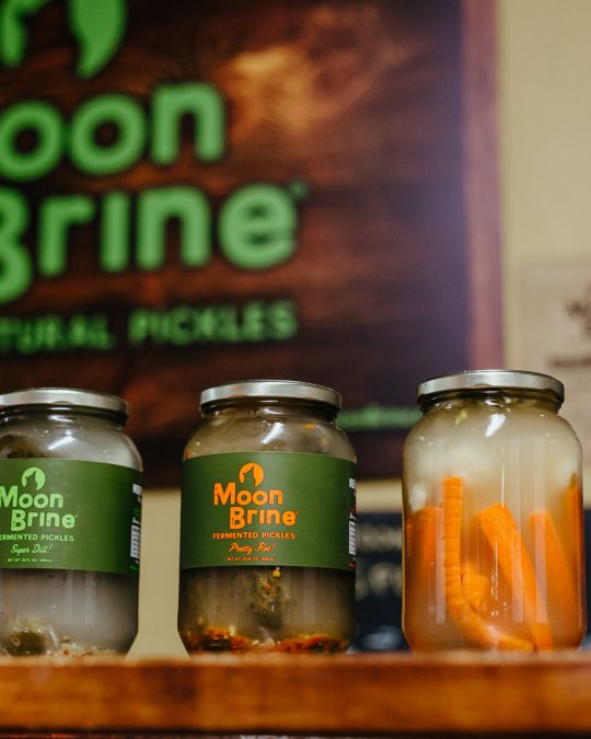 A row of jars of fermented vegetables (including carrots, pickles and beets) from the Portland pickle brand MoonBrine.