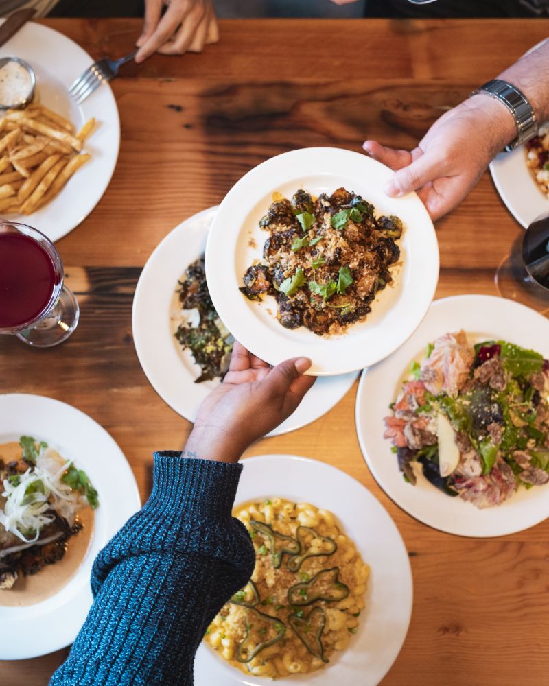 plates of food being shared on a wooden table