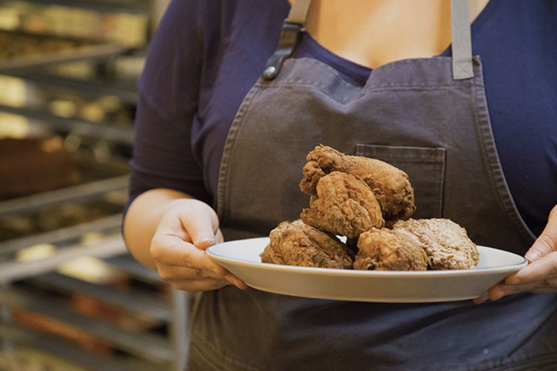 chef holding a plate full of fried chicken