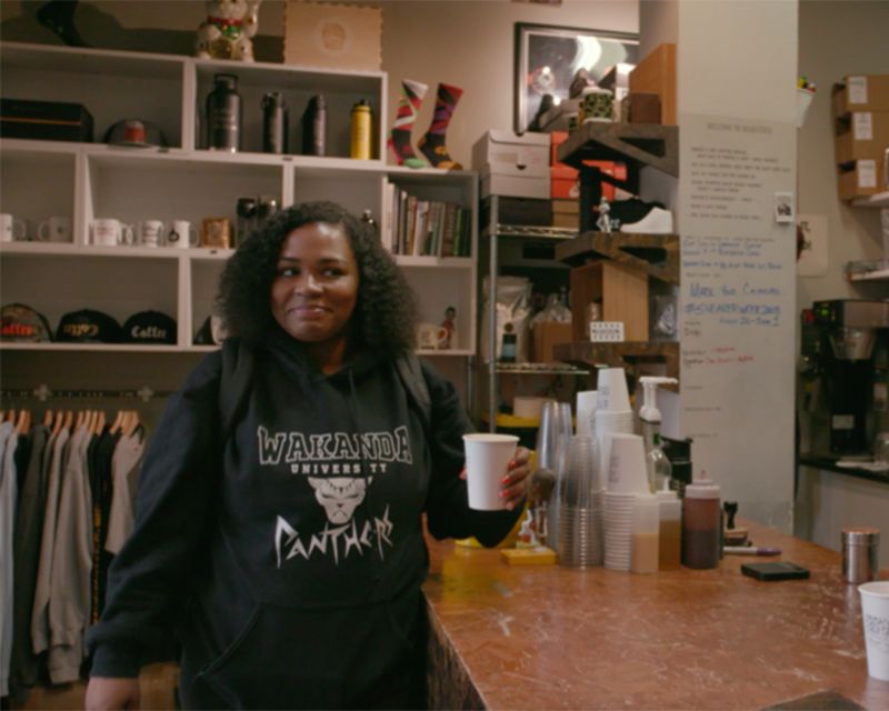 woman smiling holding a cup of coffee