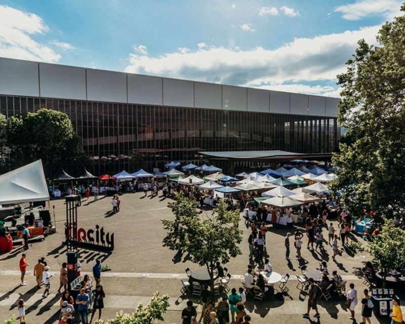 areal view of market stalls in the parking lot of a large building