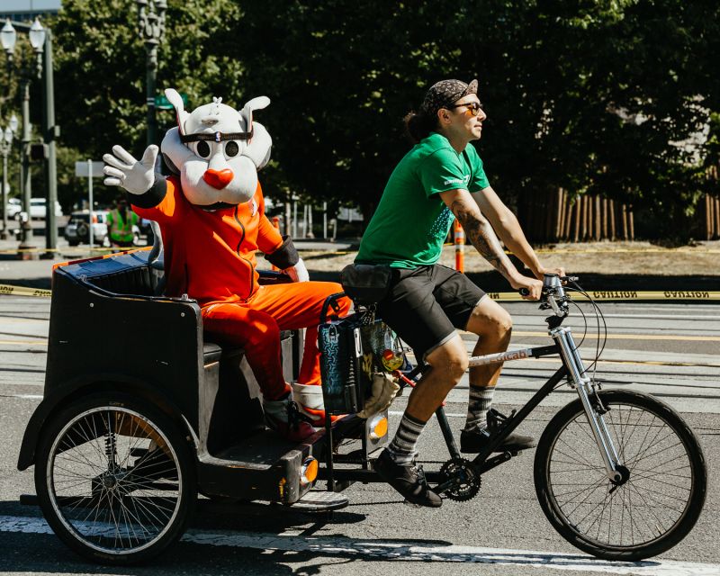 Blaze, the Trail Blazers mascot, rides by in a pedicab