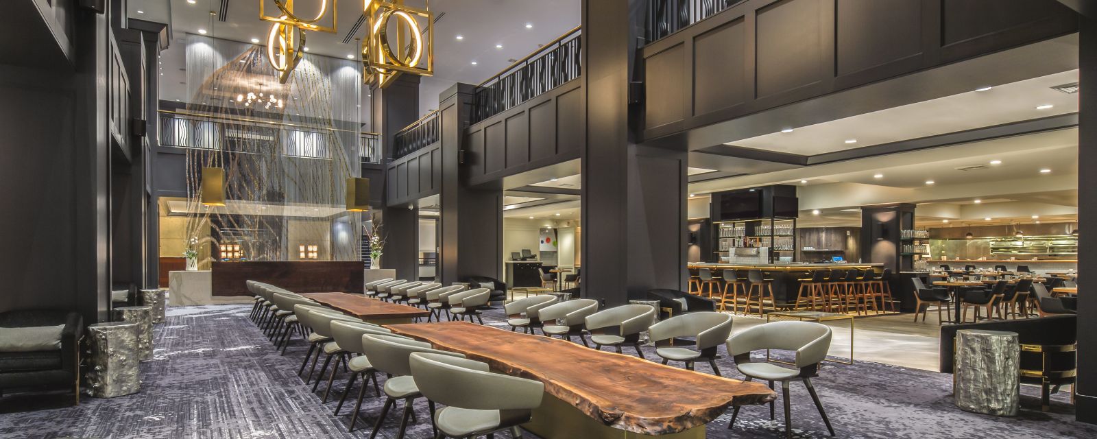 Long wooden tables set with chairs in the restaurant at the Hilton Downtown Portland