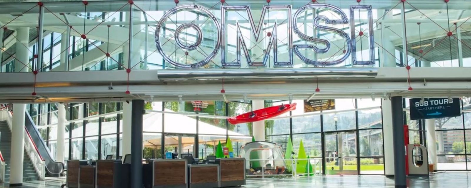 glass atrium lobby with large lettering reading OMSI