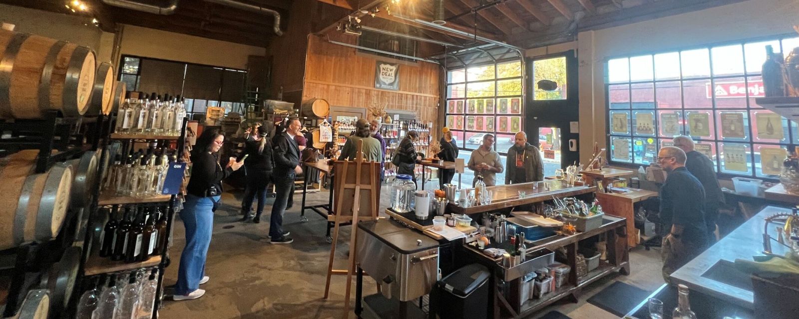 people mingle in a distillery's bottle shop and tasting room