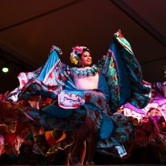 dancers in elaborate dresses on stage during portland\'s cinco de mayo fiesta