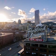 city view of downtown area with rolling hills in the background as the sun sets