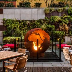 An outdoor courtyard with a fire pit in the shape of the world.