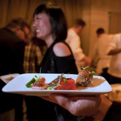 a plate of food and a smiling woman in the background