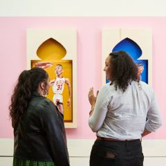 Three people viewing and chatting about a set of colorful art installations featuring basketball players at the Portland Art Museum.
