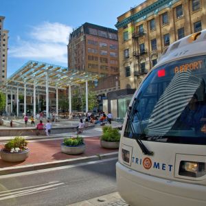 a MAX lightrail car passes by Director Park on it\'s way to the airport