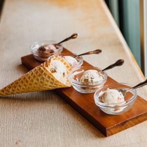 an ice cream sampler consisting of four small bowls and one sugar cone