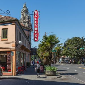 people walking on the sidewalk under a vintage Hollywood Theater sign