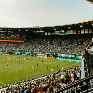 a packed crowd watches a soccer game at Providence Park stadium