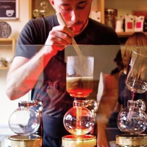 a barista creates a pour-over coffee drink