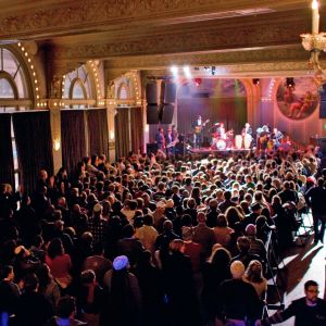 Large audience enjoying a live musical performance at the Crystal Ballroom.