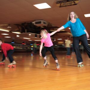 a family roller skating at Oaks Amusement Park