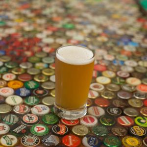 Pint of beer on bottlecap table