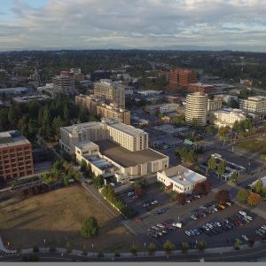 aerial view of a small downtown with about a dozen midrise buildings and a tree-filled park