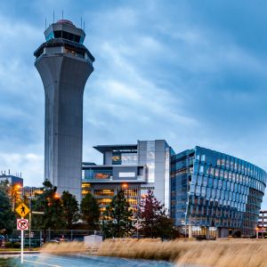 airport control tower with grey blue clouds and yellow grasses