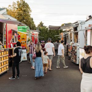 many people browsing and ordering at several food carts in two lines