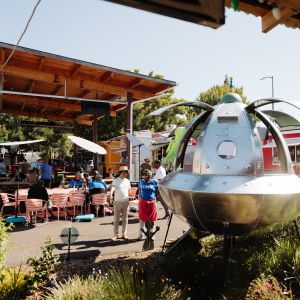 a huge decorative UFO with a table inside for seating surrounded by food carts and outdoor seating