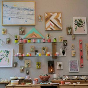 a wall display of ceramic arts and other crafts inside a ceramics studio.