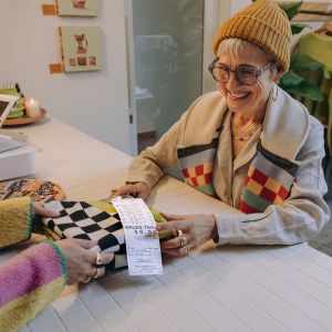 a women purchases a sweater from a register