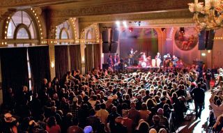 Large audience enjoying a live musical performance at the Crystal Ballroom.