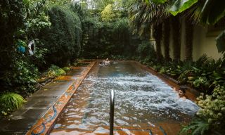 a man enjoying a warm water, outdoor pool