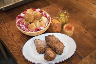 a table set with biscuits, fried chicken and beverages