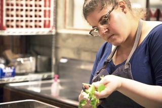 Chef cutting up green herbs