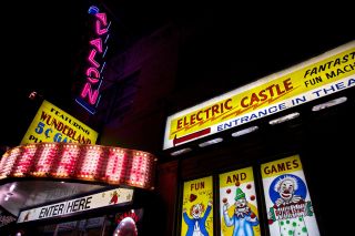 a tall neon sign reading "Avalon" with an array of other lighted signs beneath it