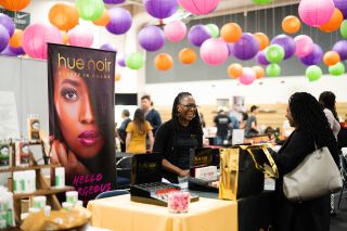 A vendor greets an attendee at My People's Market