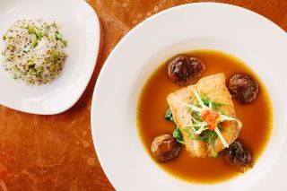 an overhead view of two colorful Peruvian dishes on bright white plates