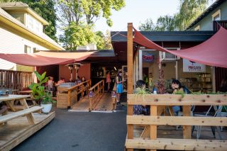 people enjoy expansive, shaded patio seating outside Mirisata restaurant on a sunny day