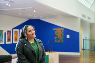 a woman stands in an art museum