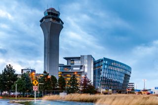 airport control tower with grey blue clouds and yellow grasses