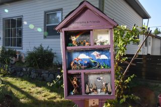 a purple box has five different mini-dine scenes in the front yard of a neighborhood home