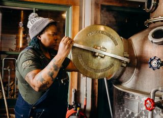 a person opens an alcohol distillation tank