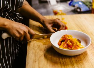 Chef Amabebe cutting up ingredients and preparing a dish.