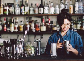Woman mixing drinks at bar