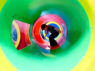 a child plays inside a green tube