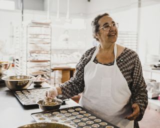 Woman preparing a muffin tin full of edible cannabis muffins.