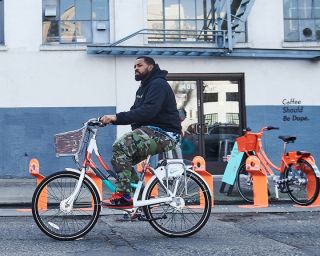 man bikes past a coffee shop on a bike designed for Biketown Culture Collection